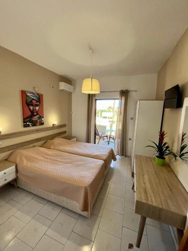 a bedroom with two beds and a television and a table at Kydonia apartments in Plataniás