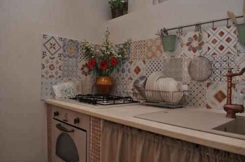 a kitchen counter with a stove and a sink at Casa Vacanze Piazzetta XI Febbraio in Alberobello