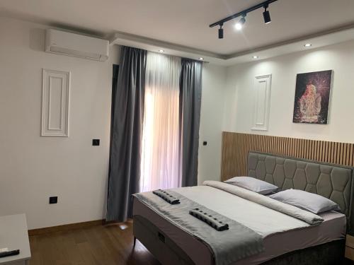 a bedroom with a large bed with two remote controls on it at AD luxury in Podgorica