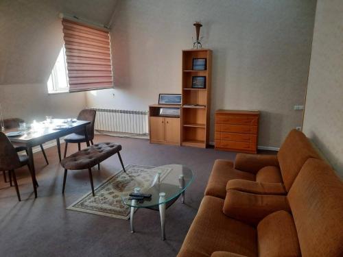 İndian hostel في باكو: غرفة معيشة مع أريكة وطاولة