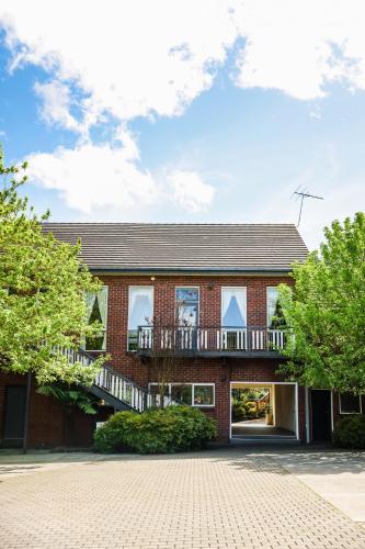 a brick house with a balcony and a driveway at Elizabethan Lodge in Melbourne