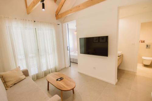 a living room with a couch and a tv on a wall at Family Resort Urania in Baška Voda