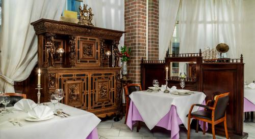 a dining room with two tables and a large wooden cabinet at Hotel im. Jana Pawła II in Wrocław