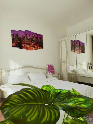 een slaapkamer met een bed met twee schilderijen aan de muur bij 9 ЖК BRAUN уютные апартаменты напротив ТРЦ Mega Alma-Ata по Розыбакиеваа in Alma-Ata