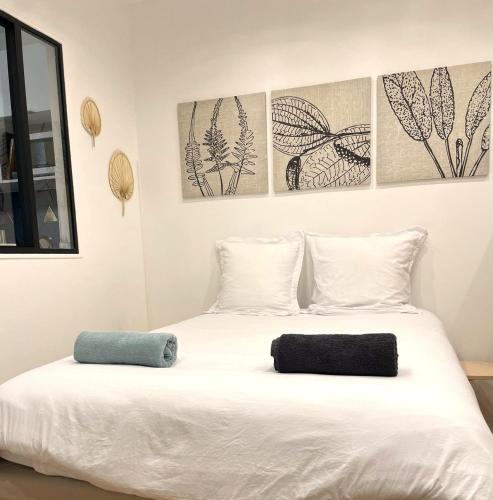 ein Schlafzimmer mit einem weißen Bett mit zwei Kissen darauf in der Unterkunft Appartement Vincennes proche métro 15 minutes Marais in Vincennes