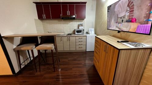 a kitchen with a counter and stools in a room at Club Satelit Zlatibor in Zlatibor