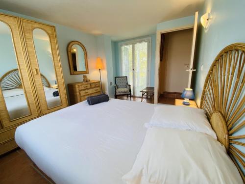 a bedroom with a large white bed and a mirror at Maison des Dunes, T2, proche plage et forêt in Anglet