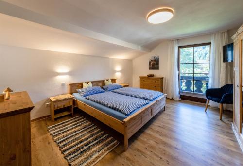 um quarto com uma cama, uma secretária e uma janela em Ferienwohnungen Veronika Wohnung 2 em Mittenwald