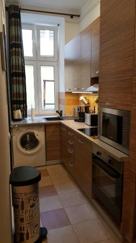 a kitchen with a sink and a microwave and a dishwasher at Home, far away from Home 2 in Budapest
