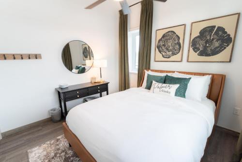 a bedroom with a white bed and a mirror at Colony Suites in Palmer