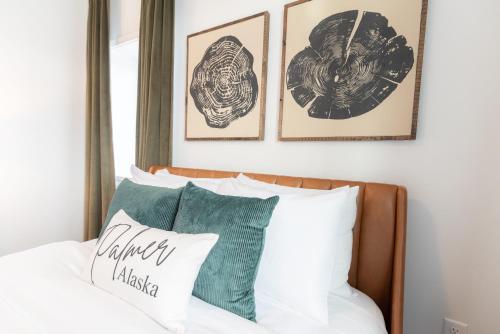 a bedroom with a bed with four pictures on the wall at Colony Suites in Palmer