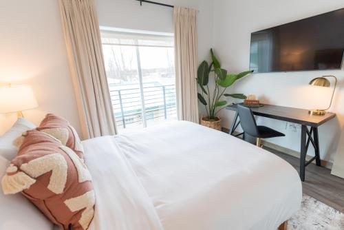 a bedroom with a bed and a desk and a window at Colony Suites in Palmer