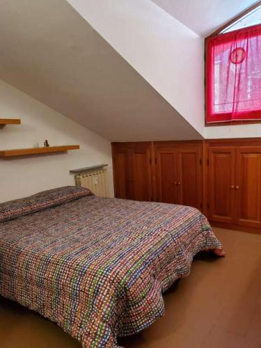 - une chambre avec un lit et une fenêtre dans l'établissement Mansarda Via Chanoux, à Saint-Vincent