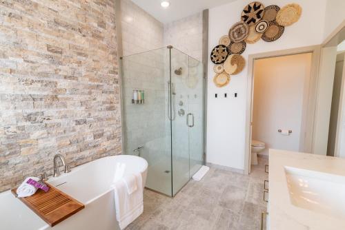 uma casa de banho com uma banheira branca e uma cabina de duche em vidro. em Colony Suites em Palmer