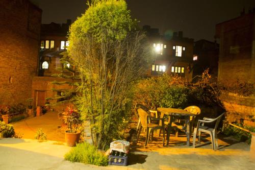 a table and chairs in a garden at night at Pradhan House - Home Stay with Garden in Bhaktapur