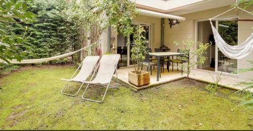 a patio with a hammock and a table and chairs at Appartement de Standing Aux Portes de Paris in Nogent-sur-Marne