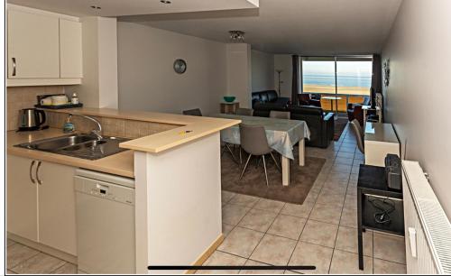 a kitchen and living room with a view of the ocean at Zeedijk Appartement in Knokke-Heist
