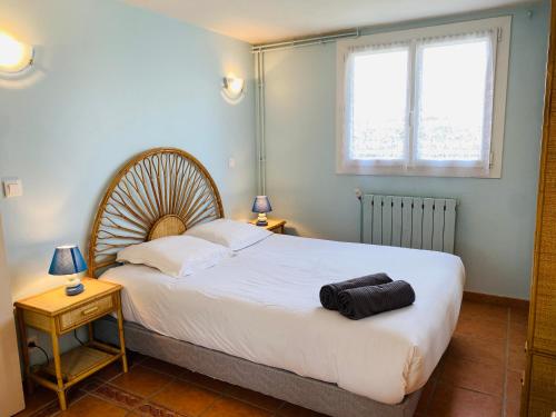 een slaapkamer met een groot wit bed en een raam bij Maison des Dunes, T2, proche plage et forêt in Anglet