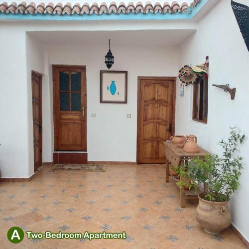 a room with two wooden doors and a table at dar zaiouane in Berga