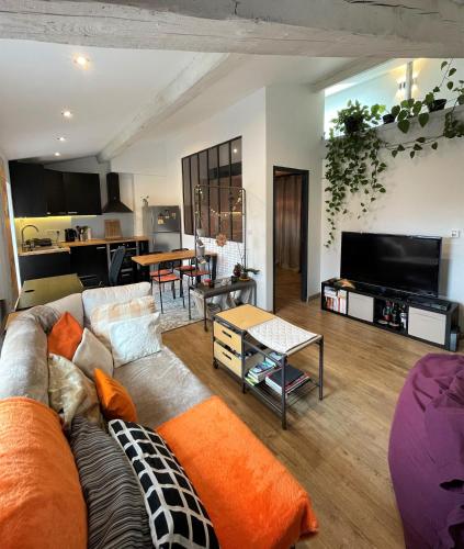 un soggiorno con divano e tavolo di T2 de 40 m2 - facile d’accès, lumineux et au calme a Saint-Genest-Lerpt