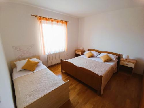 a bedroom with two beds and a window at Apartment Katarina in Split