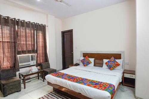 Schlafzimmer mit einem Bett, einem Schreibtisch und einem Stuhl in der Unterkunft FabHotel De Gold in Neu-Delhi