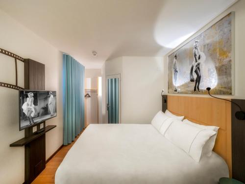 um quarto de hotel com uma cama e uma televisão em ibis Locarno em Locarno