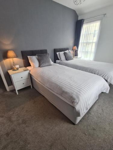 a bedroom with two beds next to a window at Meadowside Holiday Apartments in Torquay