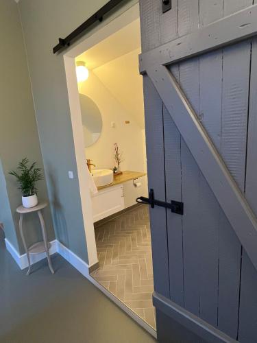 una puerta que da a un baño con lavabo en GaestFri Overnatning, en Gjern