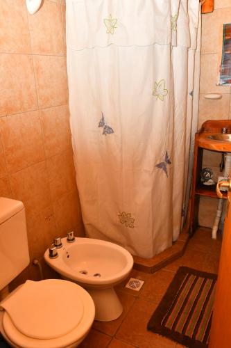 uma casa de banho com um WC e uma cortina de chuveiro em ABEDULES CABAÑAS PEHUENIA em Villa Pehuenia