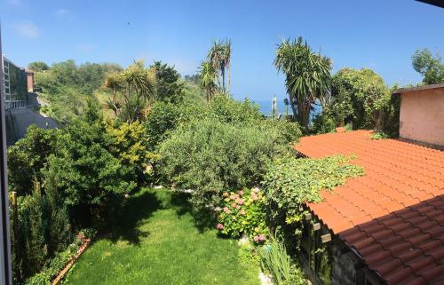 a garden with bushes and trees and a roof at Hotel Itxas Gain Getaria in Getaria