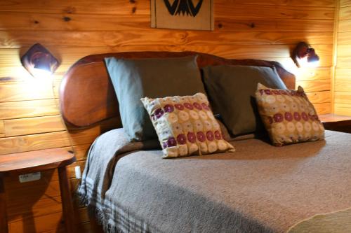 a bedroom with a bed with two pillows on it at ABEDULES CABAÑAS PEHUENIA in Villa Pehuenia