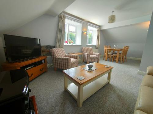a living room with a tv and a table at Pant Glas Barn in Llanbrynmair