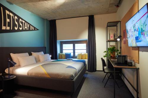 um quarto com uma cama e uma televisão de ecrã plano em The Social Hub Madrid 4 star em Madrid