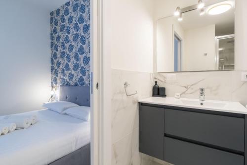a bathroom with a bed and a sink and a mirror at Easylife - Appartamento elegante moderno e accogliente - la tua oasi in città in Milan