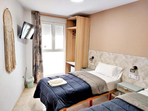 een slaapkamer met een bed en een tv. bij Habitaciones Barra89 in Valencia