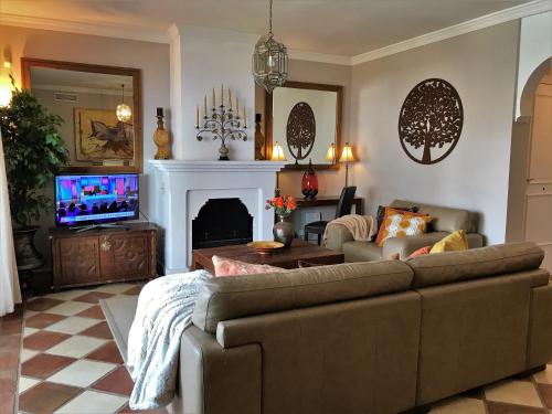 sala de estar con sofá y TV en La Perla de Marakech, en Estepona