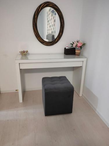 a white table with a mirror and a black ottoman at DC Ghencea 158 Self Check-in in Bucharest