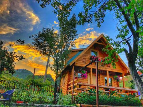 a log cabin with a sunset in the background at Brvnara Borovik in Cetinje