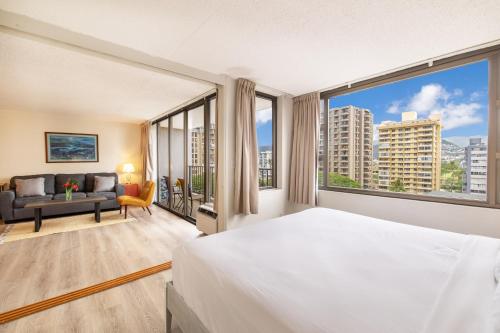 a bedroom with a bed and a large window at Mountain View Oasis, Steps from Beach with Parking! in Honolulu