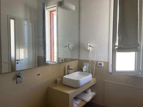 a bathroom with a sink and a mirror at SUITEBEACH b&b and resort in Marsala
