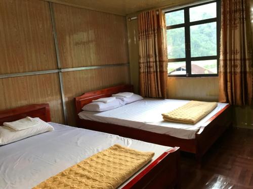 a room with two beds and a window in it at Hoàng Quân Homestay in Ba Be18
