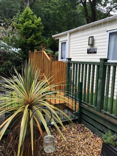 a house with a fence and a bench in a yard at 173A Woodland Way in Porthmadog