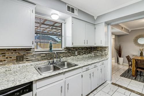a kitchen with white cabinets and a sink at Hidden Treasure in Corpus Christi