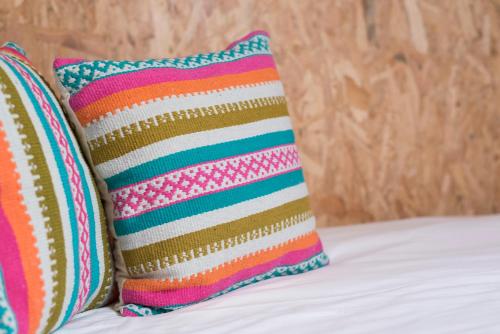 Duas almofadas coloridas estão sentadas numa cama em Fred's House Asprela no Porto