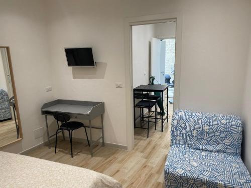 Zimmer mit einem Bett, einem Tisch und Stühlen in der Unterkunft DIMORA CAVALLERIZZA in Bari