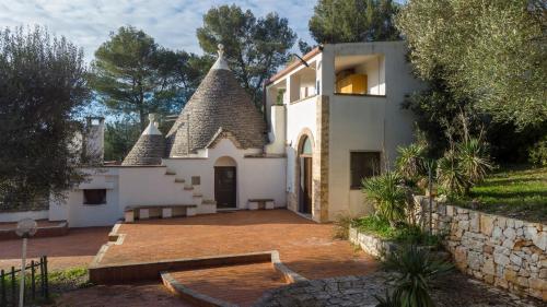 a white house with a roof with a patio at Suggestivo Trullo in valle d'itria in Ceglie Messapica