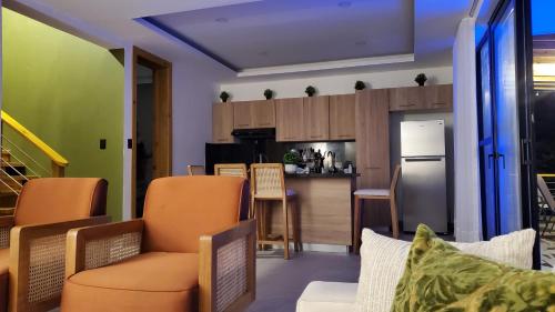 a kitchen and living room with orange chairs at Villa en la montaña in Jarabacoa
