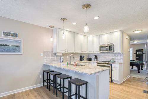a kitchen with white cabinets and a counter with stools at Doc Side in Huddleston