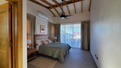 a bedroom with a bed and a large window at Villa en la montaña in Jarabacoa